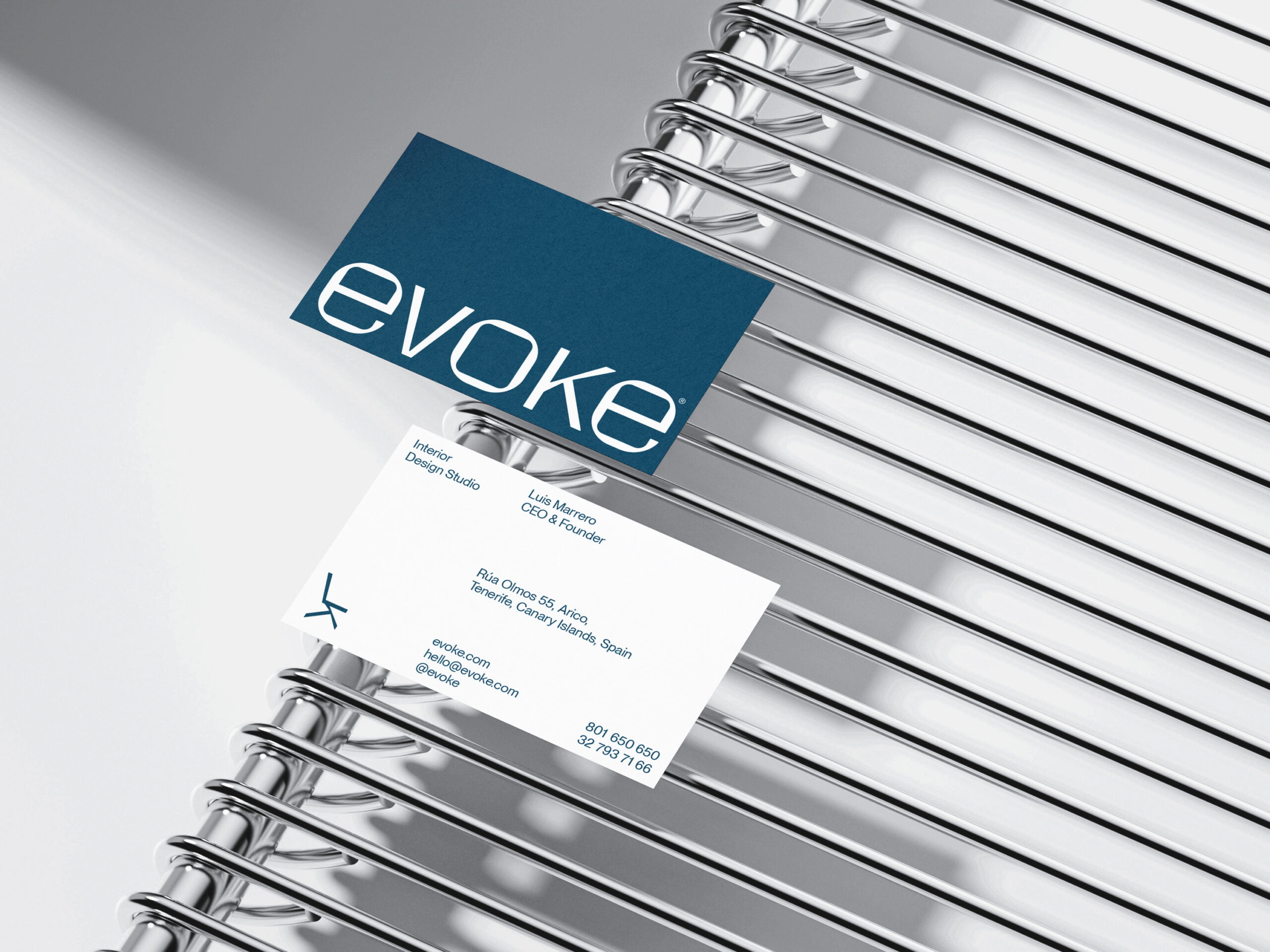 Tarjetas visita Evoke, un estudio de diseño de interiores, sobre rejilla metálica